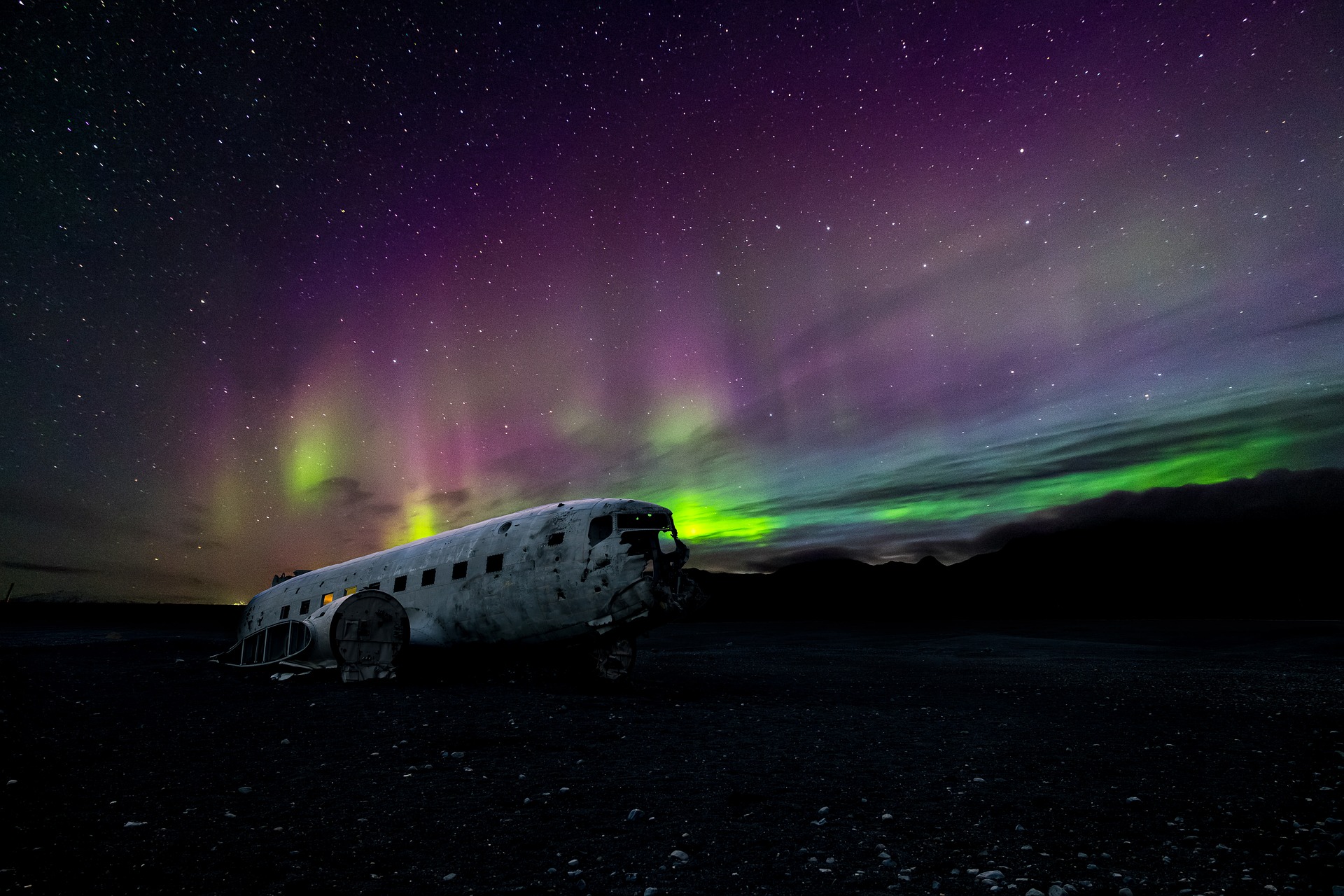 aircraft in iceland with aurora behind it