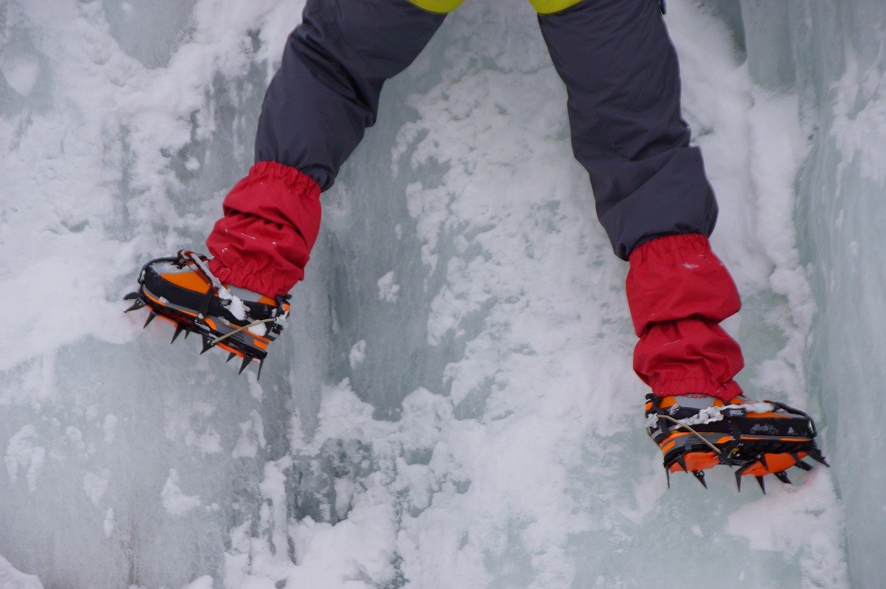 Man climbing ice in a boot with campons