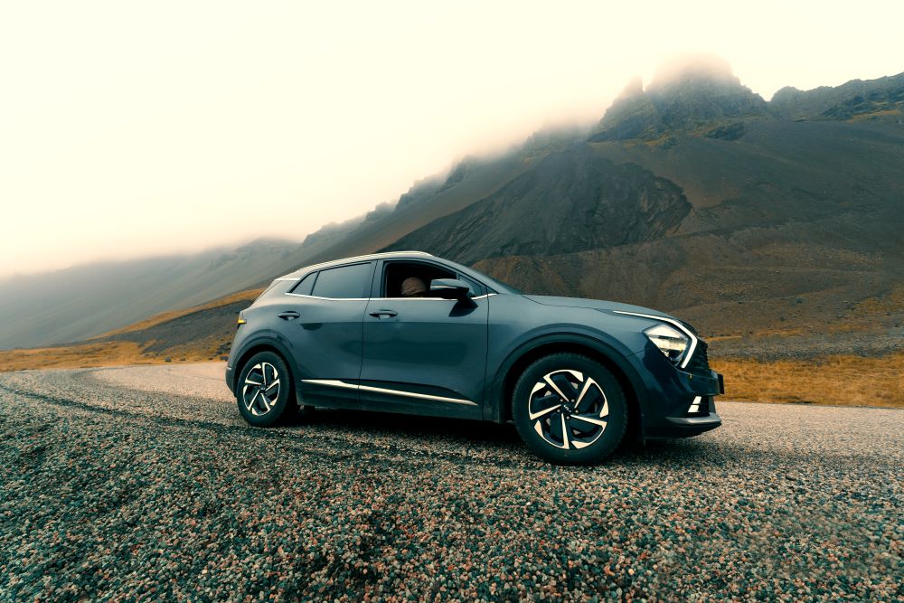 Blue rental car on the road in Iceland mountain road.
