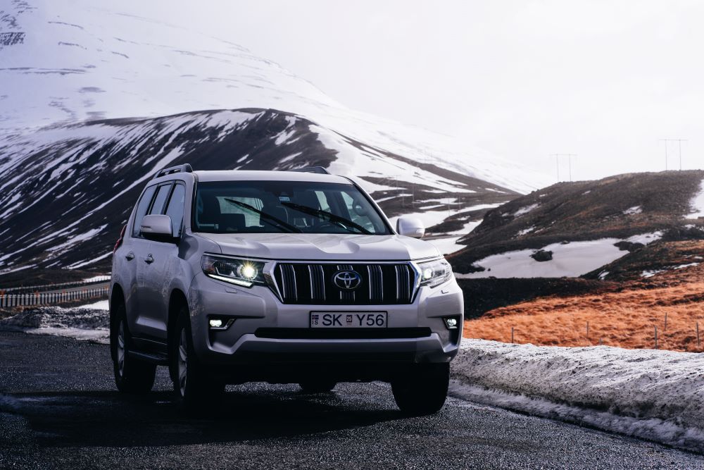 Blue car rental Toyota land crusier mountain road spring