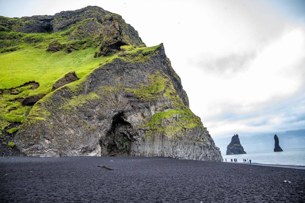 Basalt rocks and sea stacks at Reynisfjara black sand beach in Iceland.
